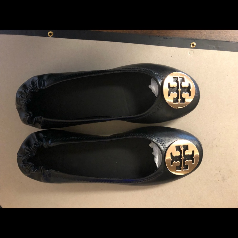 Tory Burch black flats with gold emblem detail.  Brand new never worn.